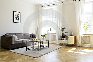 Black table on carpet in spacious living room interior with post