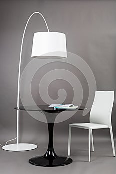 Black table, chair and the floor lamp on gray background. Modern furniture composition for interior.