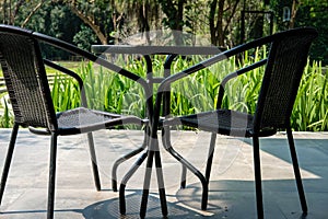 black table on terrace of house. wicker rattan chair on patio ne