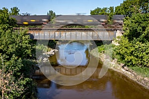 Black Tank Cars and Reflections Crossing a Bridge
