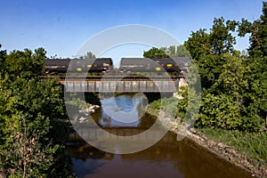 Black Tank Cars and Reflections Crossing a Bridge