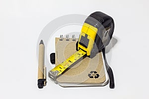 Black tape measure accessories, notebook, pen on background whit