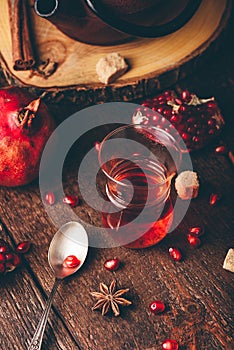 Black tea in arabic tea glass with fresh pomegranate and some spices