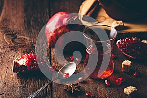 Black tea in arabic tea glass with pomegranate and spices