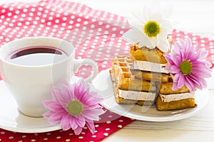 Black tea ceremony - a cup of tea, teapot, sugar, cakes, flowers on a red with white dots background