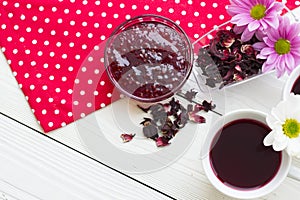 Black tea ceremony - a cup of tea, teapot, sugar, cakes, flowers on a red with white dots background