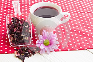 Black tea ceremony - a cup of tea, teapot, sugar, cakes, flowers on a red with white dots background