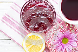 Black tea ceremony - a cup of tea, teapot, sugar, cakes, flowers on white wooden rustic background