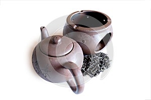 Black tea and clay teapot white background