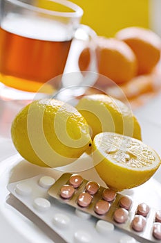 black tea with fresh lemons and flu pills in blister with thermometer - home grippe remedy photo