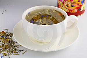 Black tea in glass cup with mint. Tea leaves in wooden spoon. On white, isolated background