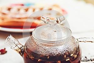 The Black Tea in the Glass Teapot,with Perspiration;Tea Drinking,Aromatized Flowers,Toned photo