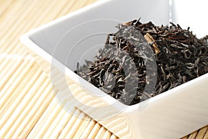 Black tea leaves in white bowl