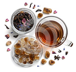 Black tea with natural flavors and a cup. Top view on white background