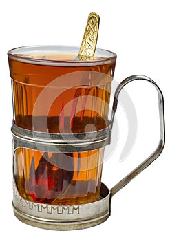 Black tea in retro glass with teaspoon and glass-holder isolated on white background