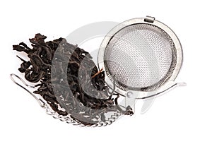 Black tea, and tea strainer with chain, isolated on a white background.