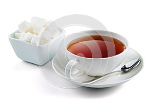Black tea with sugar cubes isolated on white