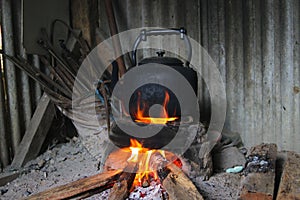 Black teapot on a traditional Sundanese wood-fired stove called hawu in a traditional kitchen.