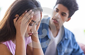Black teen guy comforting his upset female friend