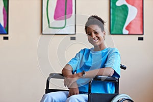 Black teenage girl with disability smiling at camera visiting art gallery