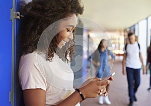 Black teenage girl using smartphone at break time in school