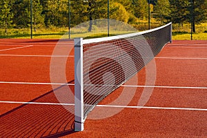 Black tennis net over a red playground outdoors