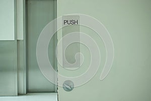 Black text push sign on white door