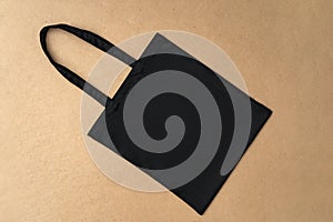 Black textile shopping bag on beige background flat lay