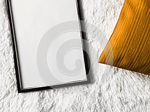 Black thin wooden frame with blank copyspace as poster photo print mockup, golden cushion pillow and fluffy white