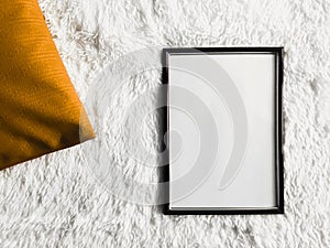 Black thin wooden frame with blank copyspace as poster photo print mockup, golden cushion pillow and fluffy white