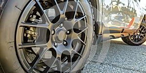 Black tire rim and disc brake of a shiny white car
