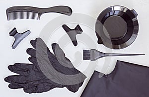 Black tools for hair coloring. Comb, bowl, brush, gloves, hair clips and Cape. Hair salon accessories