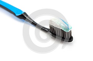 black toothbrush with the minty color of toothpaste