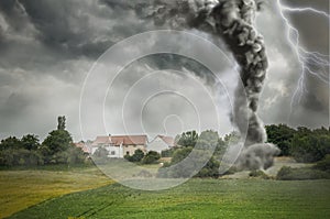 Black tornado funnel and lightning over field