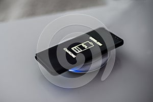 Black touchscreen smartphone wireless charging on induction charger