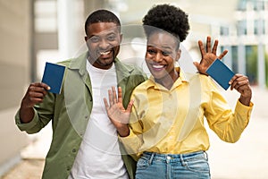 Black Tourists Couple Waving Hello Posing Holding Passports At Airport