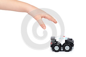 Black toy police car with kid hand, isolated on white background