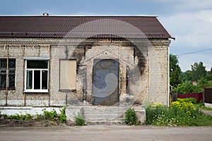 Black traces of soot on the wall of the building, remaining after the fire. Porch and new door