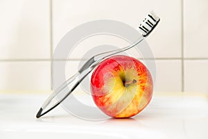 Black and transparent toothbrush with an apple.