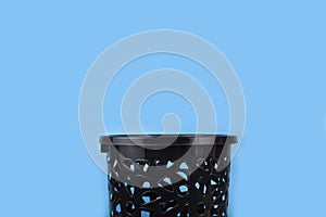 Black trash can on a blue background