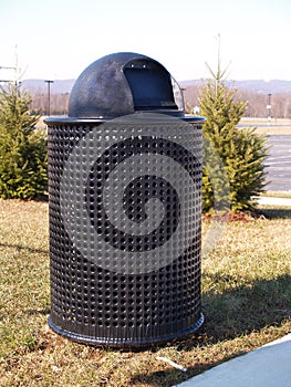 Black trash can by trees