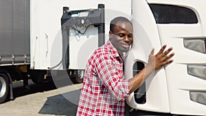 Black trucker hugging his truck vehicle for transportation. Happy african truck driver loving his job