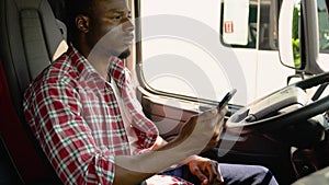 Black trucker preparing for trip. Professional trucker using truck gps navigation to transport and deliver goods to the