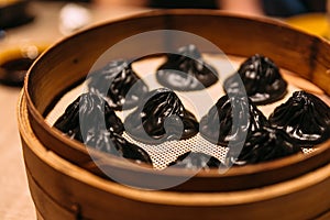 Black Truffle Xiao Long Bao Chinese Soup Dumpling inside in bamboo streamer