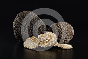Black truffles and slices on black photo