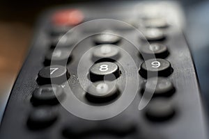 Black TV remote keypad close up