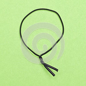 Black Twist Tie on a Green Background.