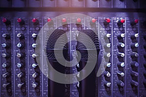 Black two wireless microphone top view on a professional audio mixer in a conference room