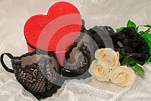 Black underwear knickers  and bra in gliter red box heart shaped    on white background