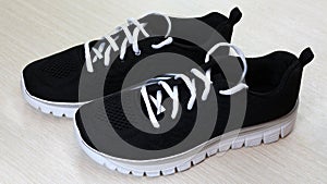 Black unisex sneakers with white sole and white laces on white background